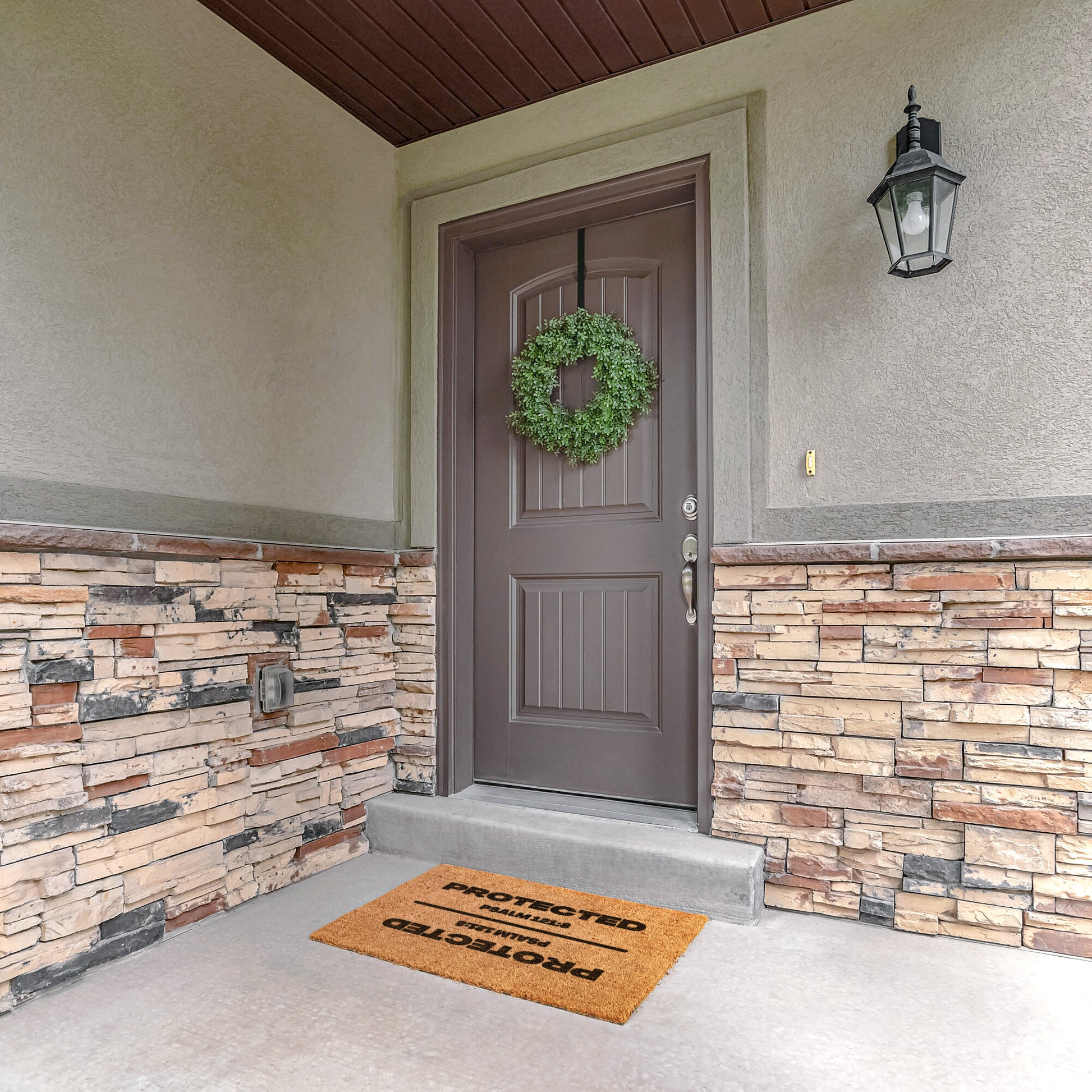 tan outdoor mat at front door with wreath